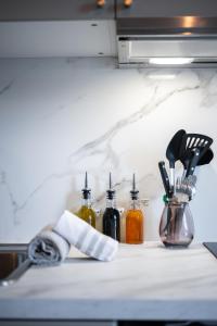 Una encimera con varias botellas de utensilios de cocina. en Cocon Azur Nice - Studio à 300m des Plages, en Niza 14 fotos más