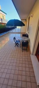 a patio with a table and chairs and an umbrella at Casa Niky  +2 photos