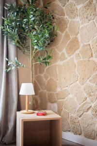 una mesa con una lámpara y una planta en una pared en Cocon Azur Nice - Studio à 300m des Plages, en Niza
