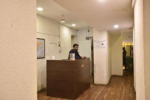 a man standing at a counter in an office at Hotel Evergreen in Mumbai