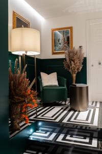 a living room with a green chair and a table at Duse Luxury Stay in Milan