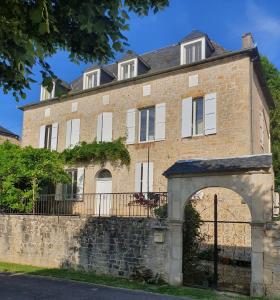an old brick building with an arch in front of it at La Maison de Famille in Padirac