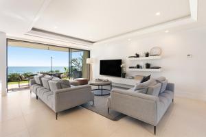 un soggiorno con divani e TV a schermo piatto di Noosa Court Apartment 03 a Noosa Heads