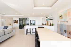 una cucina bianca e un soggiorno con divano bianco di Noosa Court Apartment 03 a Noosa Heads