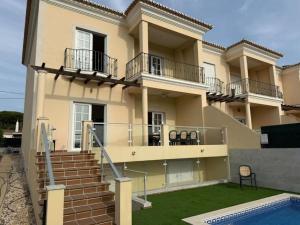 a large house with a balcony and a swimming pool at Luxury 6BR Villa Private Pool & Games Room Sleeps 12 in Quarteira