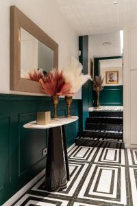 a lobby with a mirror and vases on a table at Duse Luxury Stay in Milan