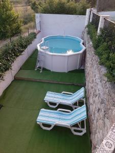 two lounge chairs and a swimming pool with a tub at CASA RURAL "ECCEHOMO de BORJA" in Borja