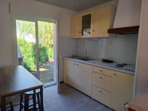 a kitchen with white cabinets and a table and a window at Maison de vacances in Lacaune