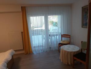 a bedroom with a bed and a table and a sliding glass door at Ferienwohnung Brigitte in Volkach