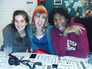 tres personas sentadas en una mesa con la boca abierta en Wayra Hostel en La Rioja