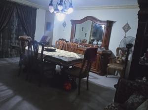a dining room with a table and chairs and a mirror at Cairo , New Nozha in Cairo