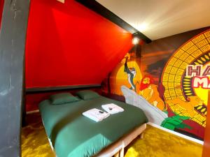Habitación con cama y pintura en la pared en Capsule Family - Sauna - Jacuzzi - Projecteur - Billard - Nintendo Switch 2 - Filet suspendu, en Crespin