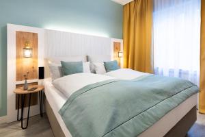 a bedroom with a large bed and a window at Garner Hotel Cologne - Engelbertz by IHG in Cologne