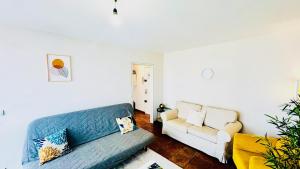 a living room with a blue couch and a white couch at Coeur de Dammarie - Balcon et Parking privé in Dammarie-lès-Lys +32 photos