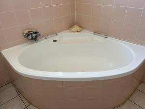 a white bath tub in a bathroom with a tile wall at Crown Eagle Guest House in Harding +10 photos