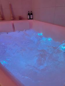 a hot tub filled with blue water with bottles of wine at La suite Tournonaise in Tournon-sur-Rhône