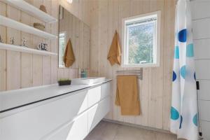 a bathroom with a tub and a sink and a window at 13370-Hojby-Havsbjergvej-11-A in Højby