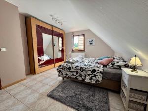 a bedroom with a bed and a large window at Maison familiale, authentique, confort et calme in Sundhoffen