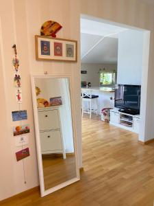 ein Wohnzimmer mit einem Spiegel und einem TV in der Unterkunft Home Sweet Home- center, sea view, sauna, balcony in Mariehamn