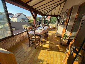 a patio with a table and chairs on a balcony at Maison familiale, authentique, confort et calme in Sundhoffen