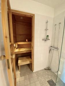 eine Duschkabine im Bad mit einer Holztür in der Unterkunft Home Sweet Home- center, sea view, sauna, balcony in Mariehamn