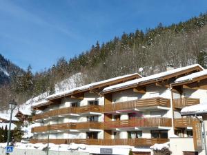 Un edificio con balcones de madera en una montaña cubierta de nieve. en Luminosité et espace, 2 pièces, centre village, proche pistes, ascenseur - FR-1-304-14, en La Clusaz