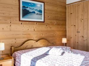 Un dormitorio con una cama y un cuadro en la pared. en Luminosité et espace, 2 pièces, centre village, proche pistes, ascenseur - FR-1-304-14, en La Clusaz