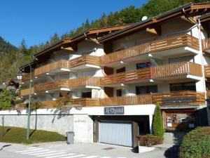 un gran edificio de apartamentos con balcones de madera. en Luminosité et espace, 2 pièces, centre village, proche pistes, ascenseur - FR-1-304-14, en La Clusaz 8 fotos más