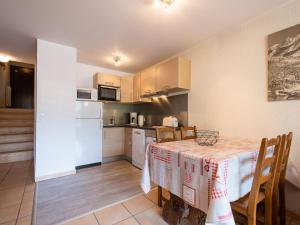 Una cocina y un comedor con mesa y armarios. en 2 Pièces 4 Pers, Proximité commerces, Garage et Ascenseur - FR-1-304-12, en La Clusaz