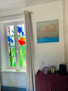 ein Fenster in einem Zimmer mit einem Vorhang und einer Kommode in der Unterkunft Laugerie Basse Gites Charming Pigeonnier Gite in Berbiguières