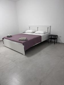 a bedroom with a large bed with a purple blanket at Apartment in Pirovac with balcony, air conditioning, Wi-Fi (4717-2) in Pirovac