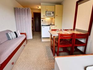 una piccola cucina con tavolo e sedie in una stanza di Studio 19m² à Chamrousse avec balcon, parking inclus - FR-1-340-146 a Chamrousse