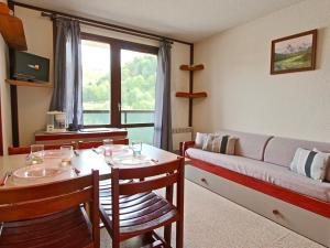 un soggiorno con un divano e un tavolo con sedie di Studio 19m² à Chamrousse avec balcon, parking inclus - FR-1-340-146 a Chamrousse