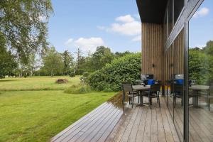 a deck with a table and chairs on a house at FJ1012-Jaegerspris-Mathiesens-Enghave-22 in Jægerspris