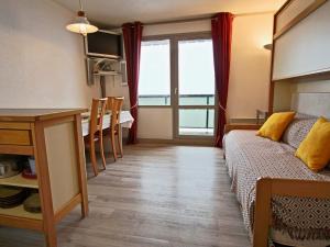 una camera con letto e tavolo e una cucina di Studio rénové 2018 avec parking couvert et animaux admis - FR-1-340-128 a Chamrousse