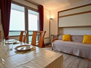 un soggiorno con un tavolo e un divano di Studio rénové 2018 avec parking couvert et animaux admis - FR-1-340-128 a Chamrousse