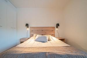 een slaapkamer met een groot bed met twee lampen bij Levillas Skimbaajankuja 7 A8 in Levi +20 foto's