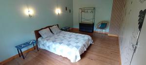 a bedroom with a bed and a table and a chair at Chambres d'hôtes Las Carbounieros in Auriac
