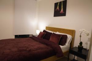 a bedroom with a bed with red sheets and pillows at Cozy 1 bedroom flat in city centre in Birmingham