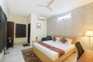 a hotel room with a large bed and a desk at FabHotel Joy Stayz Nr Hitech City in Hyderabad
