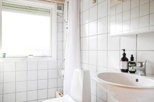 a white bathroom with a sink and a window at 13371-1-Vig-Tjornedalen-3 in Vig +15 photos