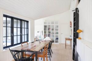 a dining room with a wooden table and chairs at 10045-1-Rorvig-Birkebakken-3 in Rørvig