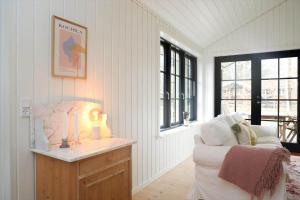a room with a couch and a table with a lamp at 10045-1-Rorvig-Birkebakken-3 in Rørvig