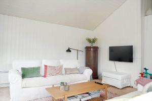 a living room with a white couch and a table at 10045-1-Rorvig-Birkebakken-3 in Rørvig