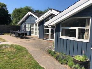 a blue house with a table and chairs in a yard at 13393-1-Vig-Lyngtoftevej-9-D in Vig