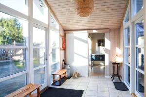 a porch with large windows and a wooden ceiling at 13393-1-Vig-Lyngtoftevej-9-D in Vig
