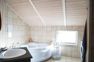 a white tub in a bathroom with a window at 13393-1-Vig-Lyngtoftevej-9-D in Vig +19 photos