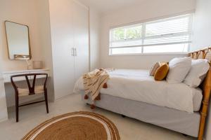 a bedroom with a bed with a window and a chair at Chic apartment with a beautiful view in Cape Town