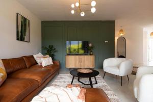 a living room with a couch and a tv at Chic apartment with a beautiful view in Cape Town
