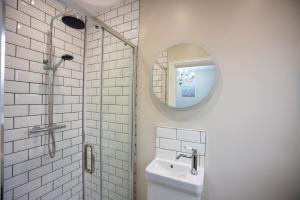 a white bathroom with a sink and a mirror at Apartment 1, Elizabeth Hall in Ledbury +10 photos
